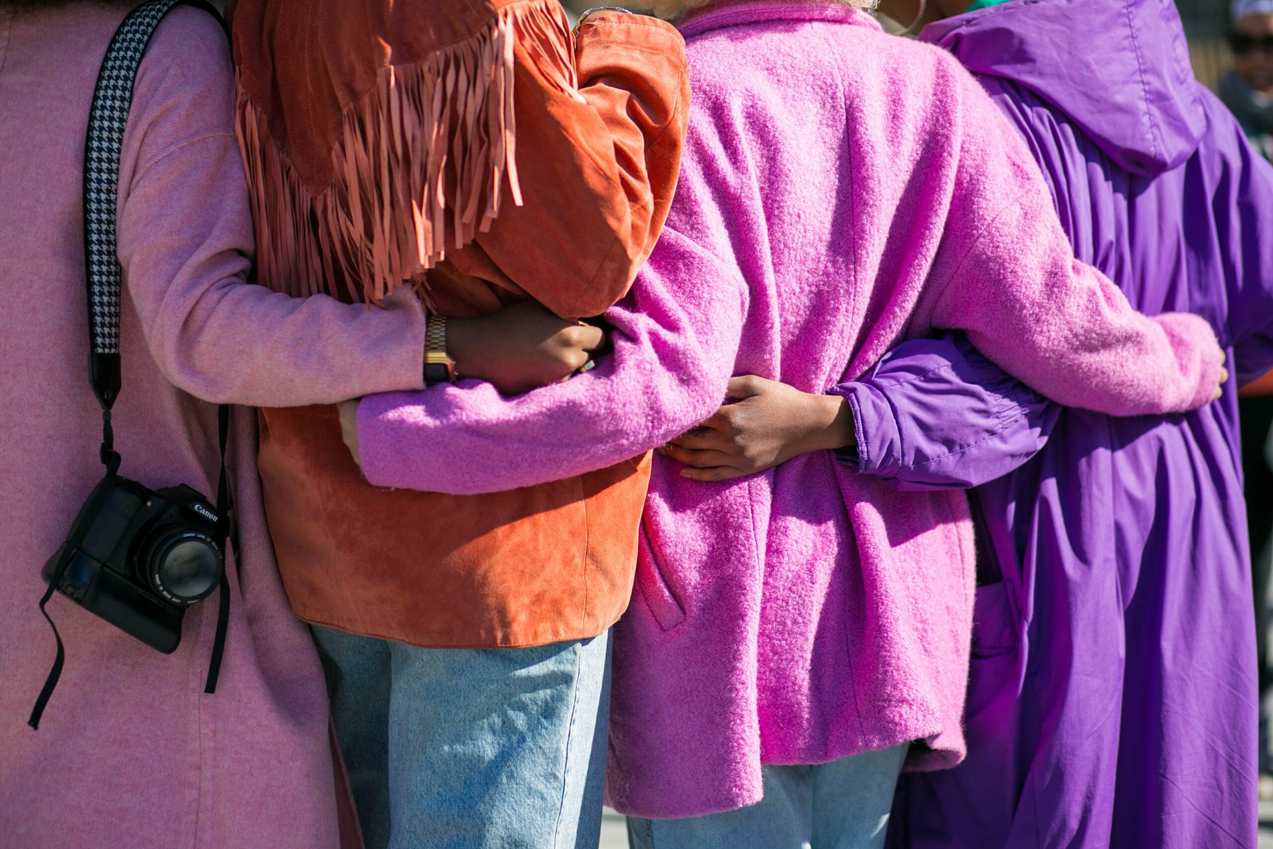 Image of 4 teens holding one another in a supportive manner